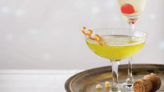 Two champagne cocktails, served in a tray with the relevant garnishes