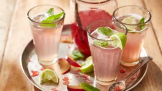 Plum Cordial served in three glasses with ice, mint sprigs and lime wedges