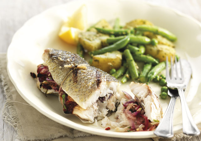 Sea Bass Filled with Fennel, Chilli and Lemon with Summer Vegetables served on a white plate with green beans and new potatoes