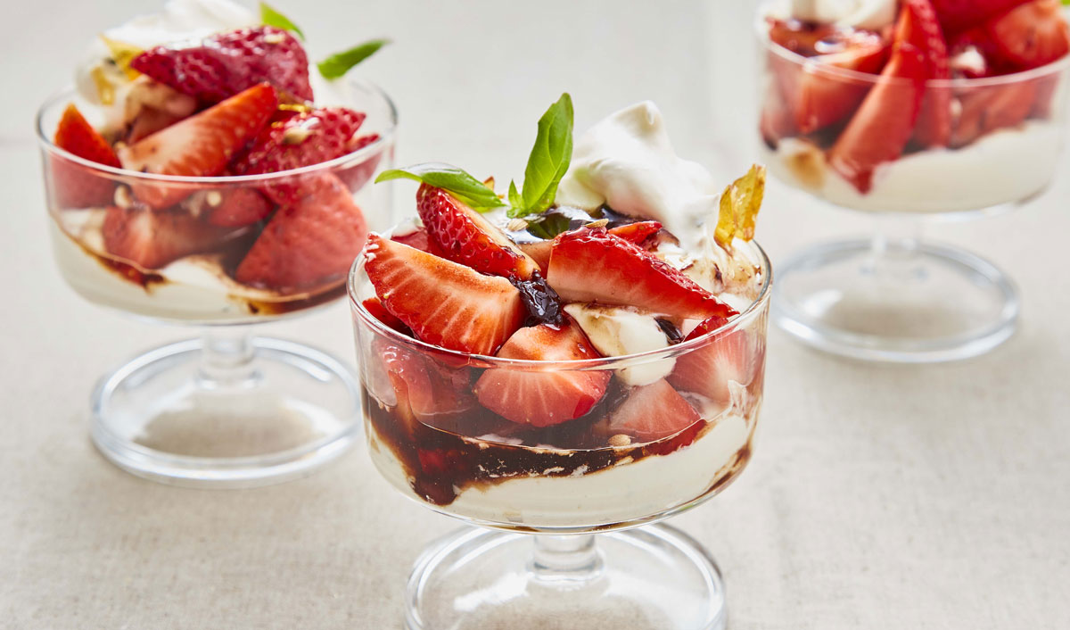 Strawberries with Black Olive Balsamic Caramel served in glass dishes with cream